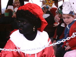 A white Dutch woman in blackface costume and afro wig as Zwarte Piet, Sinterklaas' helper.